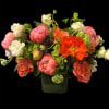 Mixed bouquet of pink, white, and orange flowers in a glass vase