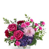 Two hot-pink roses front and center give this flower arrangement an immediate