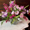 Pink and lavender flowers arranged in a clear glass vase