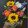 Cylinder vase includes sunflowers, roses, delphinium, alstroemeria and daisy mums