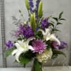 This vertical arrangement is a sophisticated blend of stately white blooms and