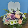 Creamy roses and soft lavender blooms nestle against a white heart-shaped plaque