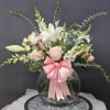 Soft white lilies and pale pink roses mingle with white snapdragons and