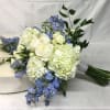 Bouquet of white hydrangeas and blue flowers with greenery