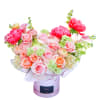 Bouquet of pink and peach flowers in a round hatbox