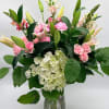 Light, airy, and elegant, this arrangement features soft pink blooms paired with
