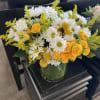 Bright yellow roses take center stage in this Sunshine flower arrangement, a