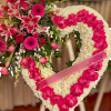 

 A beautiful heart-shaped arrangement adorned with white chrysanthemums, accented by vibrant