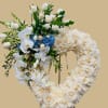 Heart-shaped floral wreath on an easel with white roses and orchids