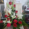 A lush cluster of red roses and white lilies creates an immediate