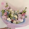 Soft pastel blooms gathered in a loose, hand-tied shape-this flower arrangement is