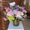 Soft pink roses and a pale lavender chrysanthemum take center stage in