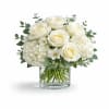 Creamy white roses nestled above rounded white hydrangea blooms give this flower
