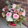Large pink roses paired with coral alstroemeria and soft white chrysanthemums create