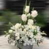 White roses and lilies arranged in a glass vase