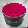 Round box of bright pink roses with a clear lid