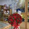 Red rose bouquet in a white box with a clear balloon above it