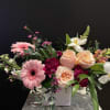Pink gerbera daisies and peach roses in a white vase