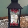 Black lantern with red roses and a memorial message inside