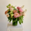 Coral charm peonies and peach mini roses take center stage in this