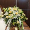 A graceful, full-length casket spray designed for a funeral or memorial service