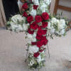 A large, traditional sympathy cross arranged for a funeral service, this floral