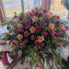 A lush, low centerpiece arranged for maximum table impact, this sympathy-style floral