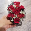 Small bouquet of red roses with white filler flowers and black ribbon