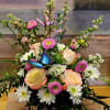Mixed bouquet with peach roses, white daisies, and pink blooms with butterfly picks