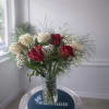 Deep red and creamy white roses mingle in a clear glass vase