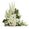White lilies and roses arranged in a low spray with greenery