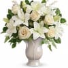 White lilies and cream roses arranged in a beige vase
