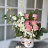 Pink roses and white orchids in a Snoopy mug vase
