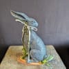A grafite rabbit figurine on a natural wood riser makes this decorative