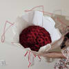 Large bouquet of red roses wrapped in white paper with pink ribbon