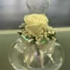 Single pale yellow rose in a clear glass vase with a ribbon bow