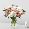 Mixed bouquet of white daisies and mums with peach roses in a clear glass vase