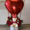 Red heart balloon above roses, a teddy bear, and chocolates in a white box