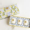 Two boxed mini candle gift sets with lemon-patterned packaging and three candles visible