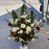 Spray arrangement in a white vase, with red and white fresh blooms