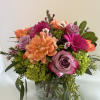 An Vase Arrangment with beautiful purple roses, Orange Dahlias and spray roses
