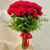 Red roses in a clear glass vase with a red ribbon