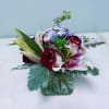 Mixed bouquet in a square glass vase with roses and lilies