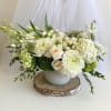 White floral arrangement in a round vase with roses and chrysanthemums