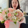 Woman holding a pastel pink flower box with roses and hydrangeas