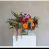 A lush, overflowing mixed-color arrangement built in a clear glass vase-The Elle