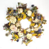 Dried floral wreath with cream, yellow, and purple blooms