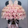 Pink roses arranged in a polka-dot hat box with a ribbon and bunny ears