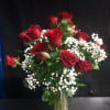 Deep, velvety red roses take center stage in this romantic flower arrangement