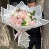 Large bouquet of pink and white roses wrapped in translucent paper